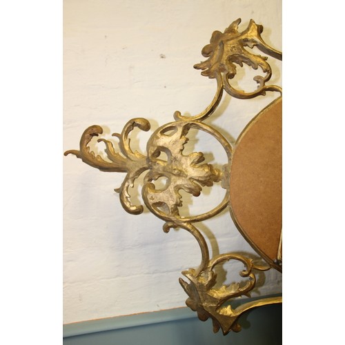 1027 - A late 19th/early 20th century French Rococo style gilt wood wall mirror, the oval mirror plate encl... 