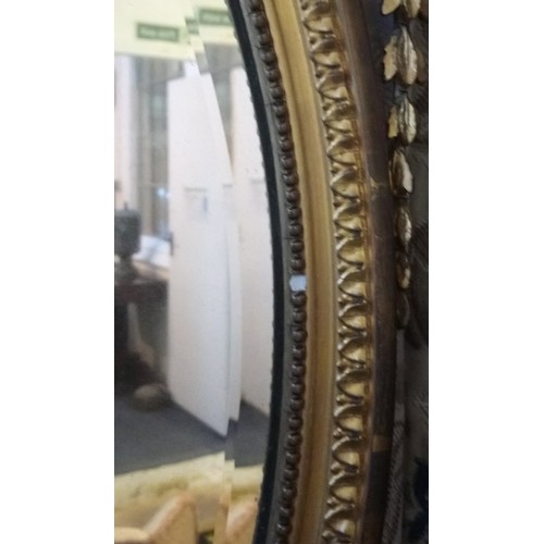 1023 - A pair of 19th century gilt wood and gesso oval wall mirrors, each with an Adams style, urn shaped c... 