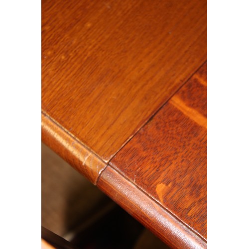 1029 - An early 20th century golden oak extending dining table, the rectangular top with moulded and rounde... 