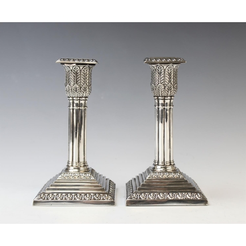 116 - A pair of silver plated candlesticks, each designed as a reeded column with palm leaf wrapped capita... 