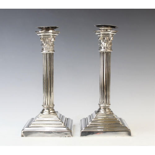 116 - A pair of silver plated candlesticks, each designed as a reeded column with palm leaf wrapped capita... 