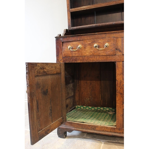 558 - A George III oak North Walian dresser, the high back with a moulded cornice, over three enclosed she... 