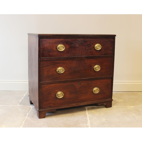 560 - An early 19th century mahogany chest of drawers, formed as three drawers set with oval brass handles... 