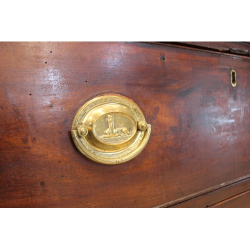 560 - An early 19th century mahogany chest of drawers, formed as three drawers set with oval brass handles... 