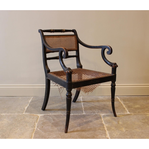 561 - A painted Regency elbow chair, in the manner of Thomas Hope, the rattan panel back flanked by turned... 