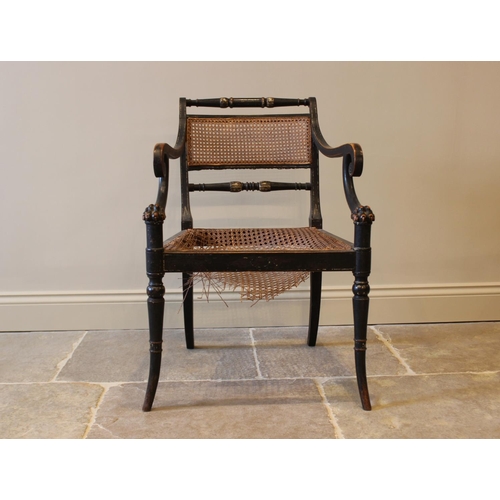 561 - A painted Regency elbow chair, in the manner of Thomas Hope, the rattan panel back flanked by turned... 