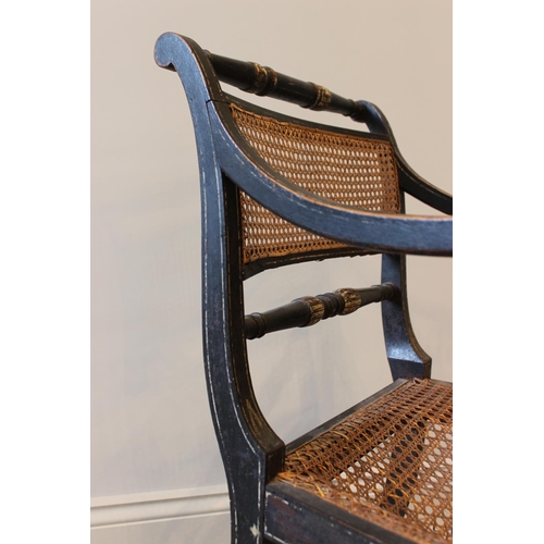 561 - A painted Regency elbow chair, in the manner of Thomas Hope, the rattan panel back flanked by turned... 