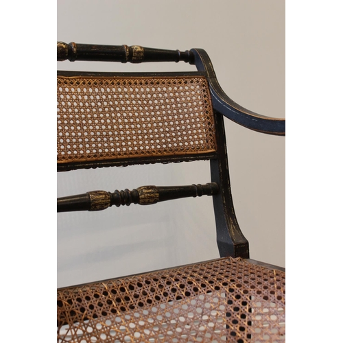 561 - A painted Regency elbow chair, in the manner of Thomas Hope, the rattan panel back flanked by turned... 