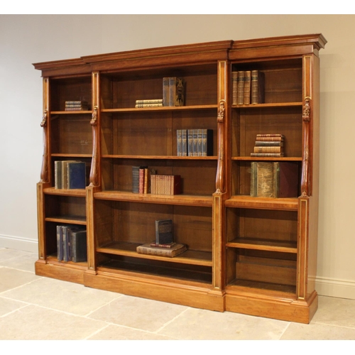 562 - A mid 19th century satin birch breakfront open bookcase, the moulded cornice above the central secti... 