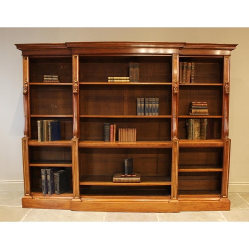 562 - A mid 19th century satin birch breakfront open bookcase, the moulded cornice above the central secti... 