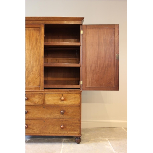 566 - A mid-19th century mahogany linen press, the angular cornice above a pair of panelled cupboard doors... 