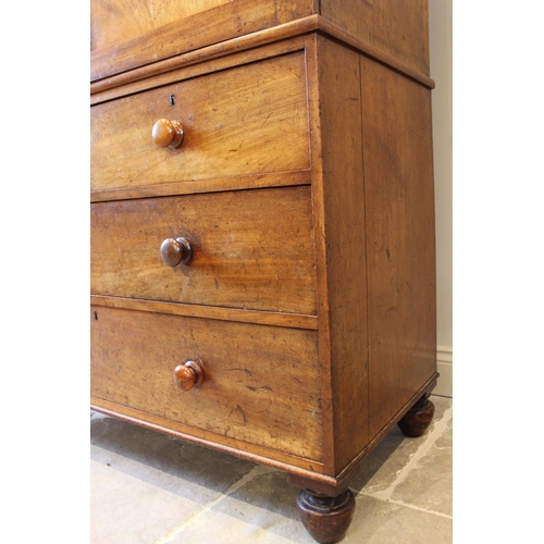 566 - A mid-19th century mahogany linen press, the angular cornice above a pair of panelled cupboard doors... 