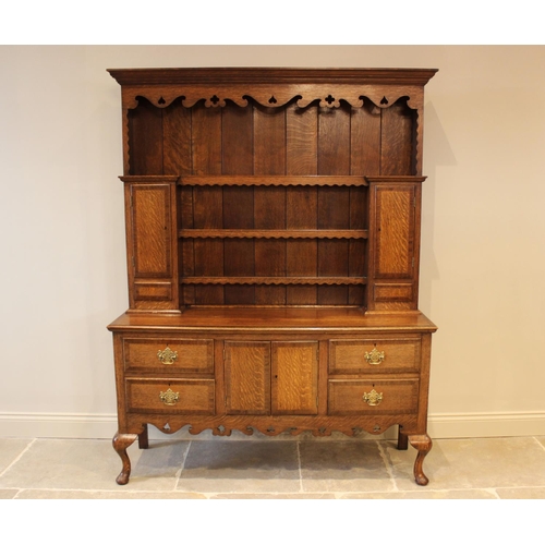 568 - A George III style oak high back dresser, mid 20th century, with shaped frieze over three enclosed s... 