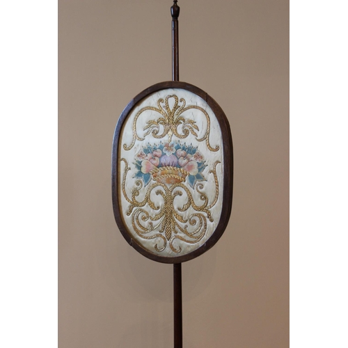 573 - A 19th century and later mahogany pole screen, the glazed oval panel applied with scrolling gold wor... 