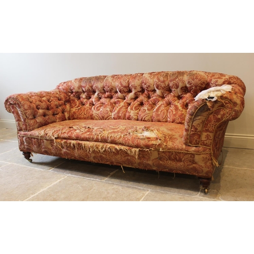 577 - A 19th century button back chesterfield type sofa, upholstered in foliate fabric and raised on turne... 