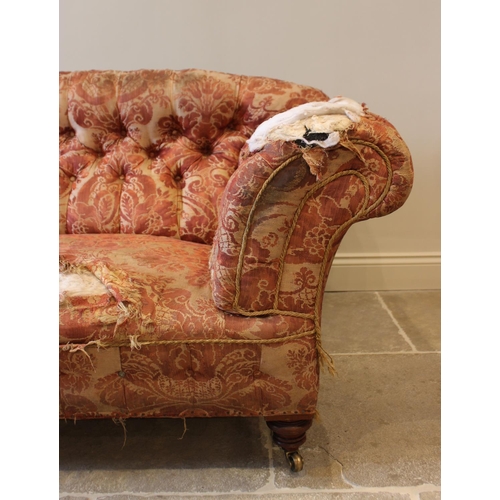 577 - A 19th century button back chesterfield type sofa, upholstered in foliate fabric and raised on turne... 