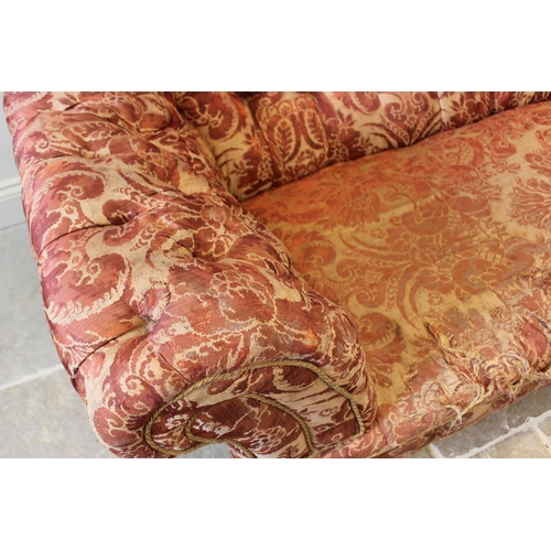 577 - A 19th century button back chesterfield type sofa, upholstered in foliate fabric and raised on turne... 