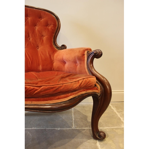 578 - A Victorian mahogany framed button back salon chair, red velour upholstery with padded arms extendin... 