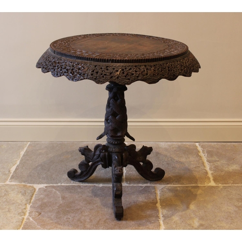 587 - A late 19th century Anglo Indian hardwood pedestal table, the circular table top carved with an oute... 