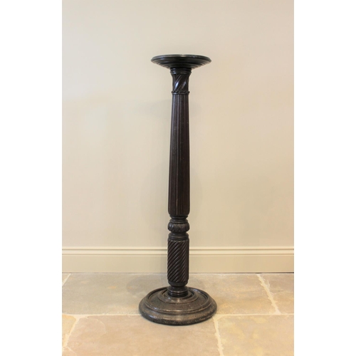 591 - A 19th century mahogany torchere, the reeded and wrythen column raised upon a turned circular base, ... 