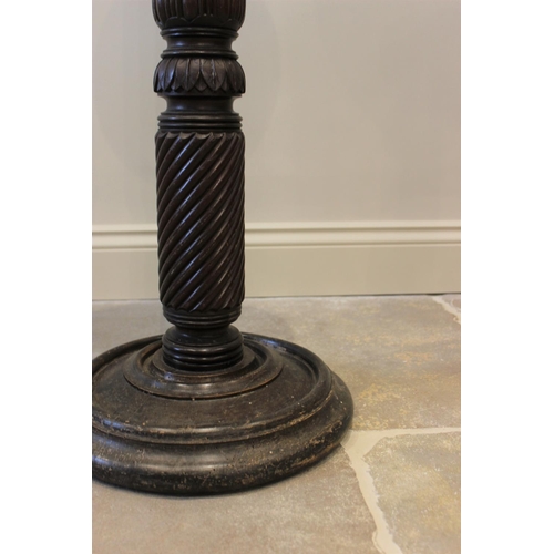 591 - A 19th century mahogany torchere, the reeded and wrythen column raised upon a turned circular base, ... 