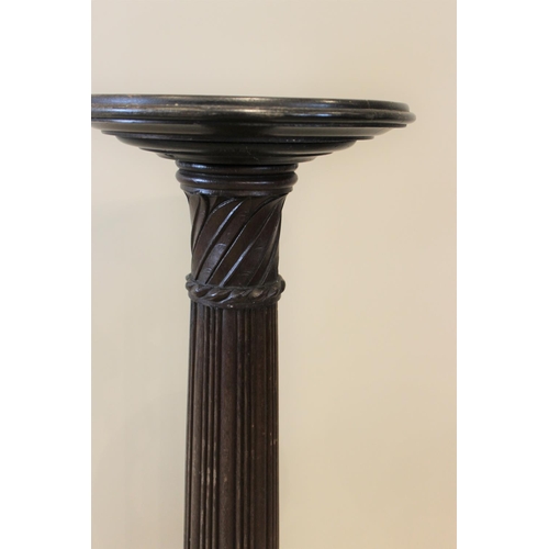 591 - A 19th century mahogany torchere, the reeded and wrythen column raised upon a turned circular base, ... 