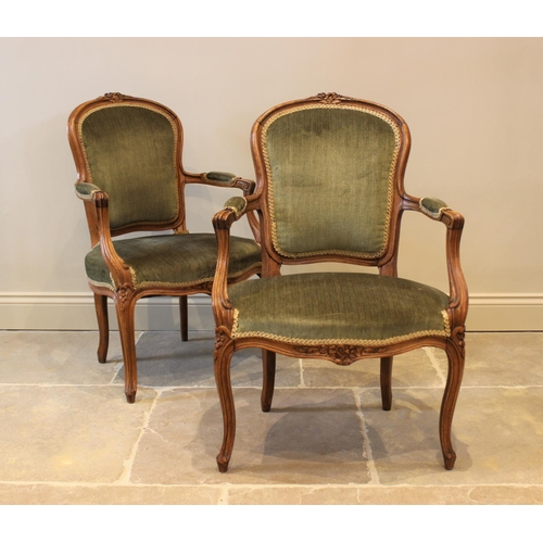 597 - A pair of French stained beech framed fauteuils, late 19th century, each upholstered in green velour... 