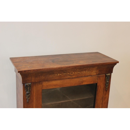 602 - A Victorian walnut pier cabinet, with foliate inlaid motif above a single glazed door, enclosing two... 