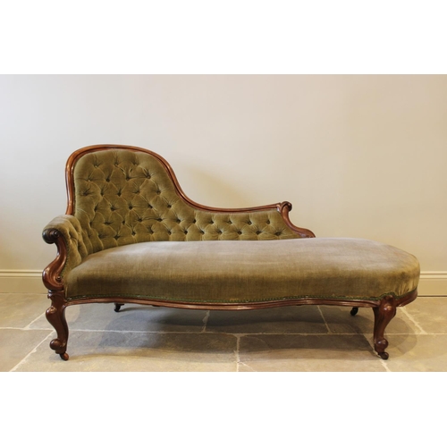 606 - A Victorian mahogany framed and green velour chaise lounge, the arched button back extending to a ca... 