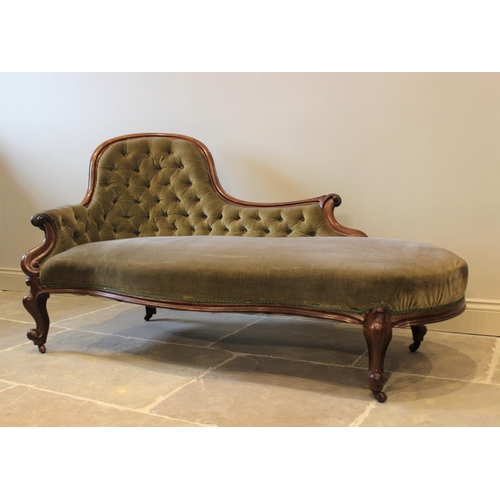 606 - A Victorian mahogany framed and green velour chaise lounge, the arched button back extending to a ca... 