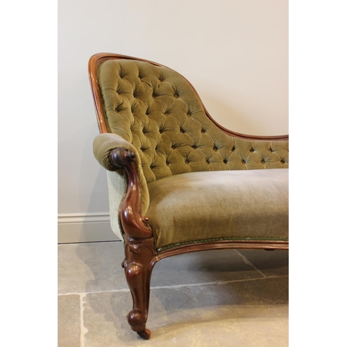 606 - A Victorian mahogany framed and green velour chaise lounge, the arched button back extending to a ca... 