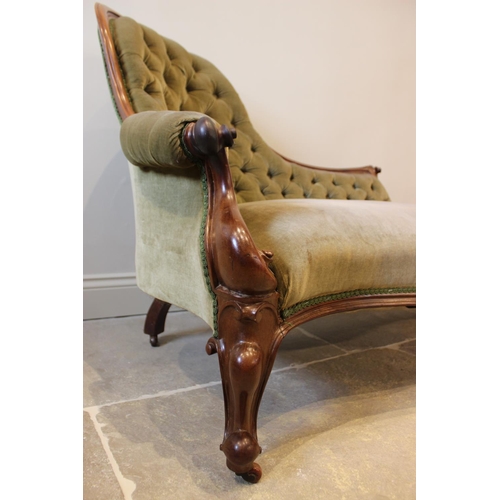 606 - A Victorian mahogany framed and green velour chaise lounge, the arched button back extending to a ca... 