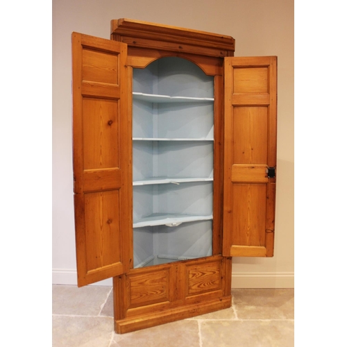 607 - A Victorian style pine free standing corner cupboard, the moulded cornice over a pair of panelled do... 