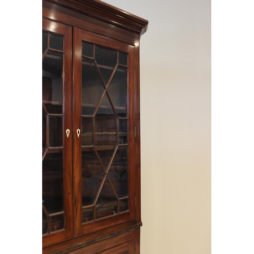 610 - A 19th century mahogany freestanding corner cabinet, the moulded cornice above a pair of astragal gl... 