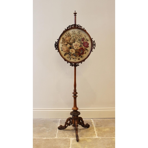 611 - A mid 19th century walnut pole screen, the circular foliate needlework panel within a glazed frame, ... 