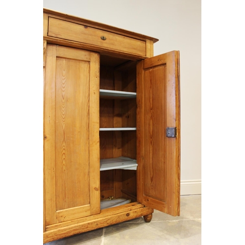 628 - An early 20th century pine hall cupboard, the single frieze drawer above a pair of cupboard doors, f... 