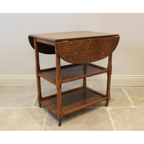 629 - A 1920’s Art Deco honey oak drinks trolley, the moulded drop leaf top raised upon chamfered supports... 