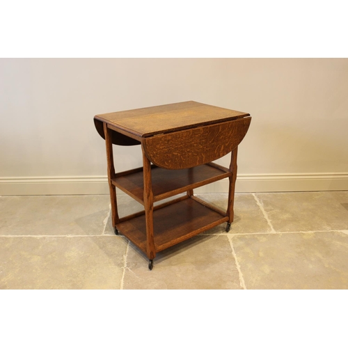 629 - A 1920’s Art Deco honey oak drinks trolley, the moulded drop leaf top raised upon chamfered supports... 