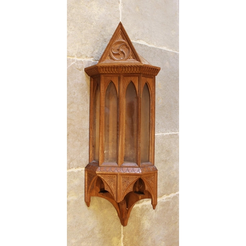 638 - A carved oak Gothic revival wall hanging corner cupboard, 20th century, with four arched glazed pane... 