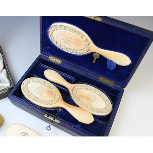 64 - A cased set of carved ivory brushes and a mirror, each piece with intricately carved frieze of roses... 