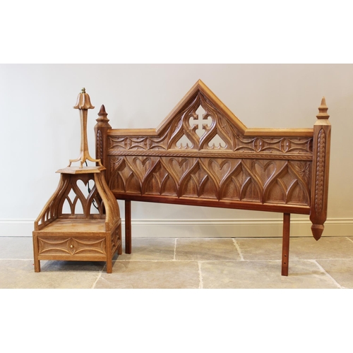 646 - A carved oak Gothic revival headboard, 20th century, 151cm wide, along with a matched bedside table ... 