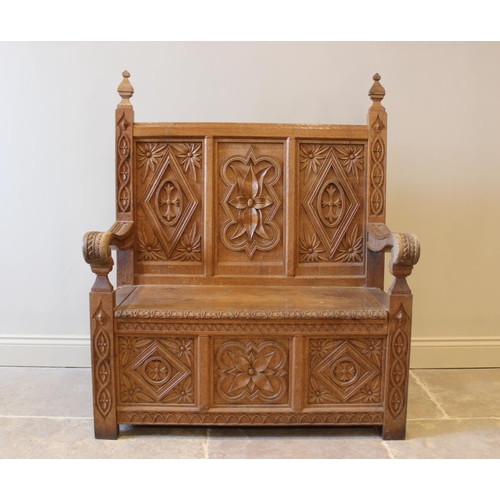 648 - A carved oak box seat settle, 20th century, the three panel back carved with foliate sprays, 130cm H... 