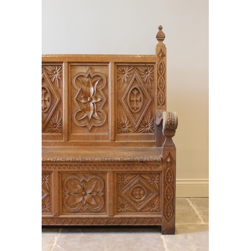 648 - A carved oak box seat settle, 20th century, the three panel back carved with foliate sprays, 130cm H... 