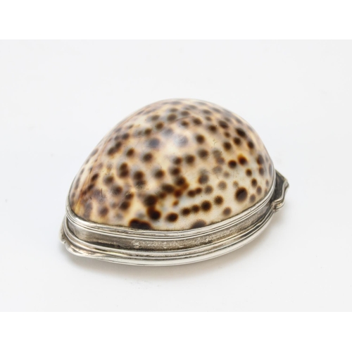 85 - A 19th century white metal mounted cowrie shell snuff box, the hinged cover embossed with flora and ... 