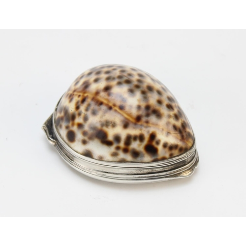 85 - A 19th century white metal mounted cowrie shell snuff box, the hinged cover embossed with flora and ... 