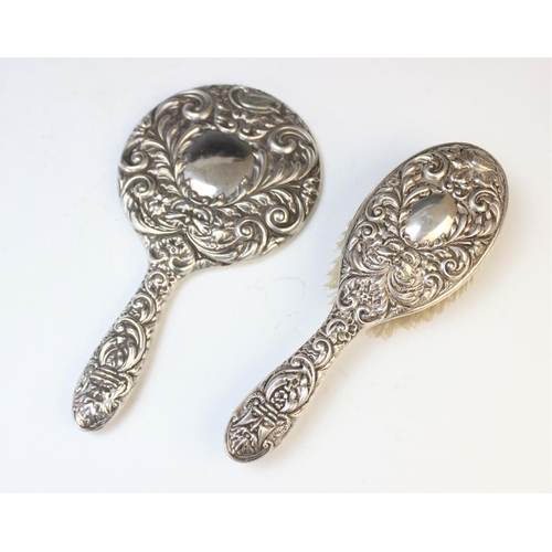 90 - A silver mounted mirror and matching hairbrush W I Broadway & Co, Birmingham 1962-5, each embossed w... 