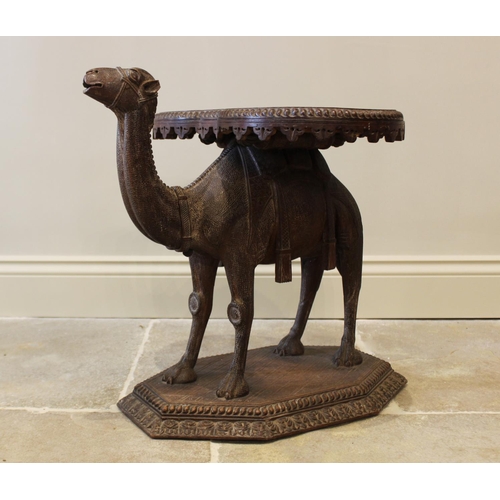 579 - An Anglo-Indian camel form occasional table, 19th century, the kidney shaped table top carved with a... 