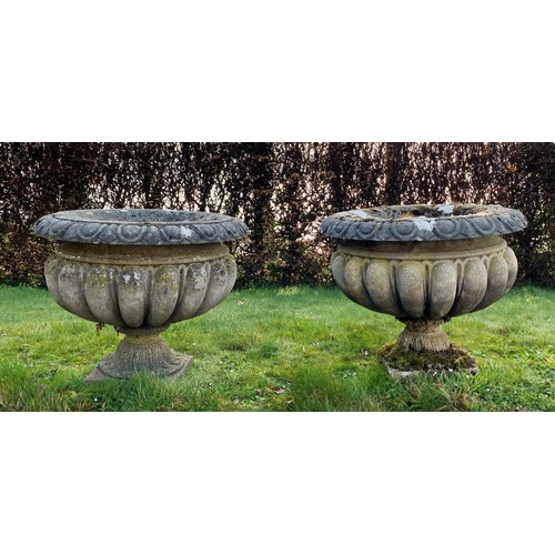 652 - Three reconstituted stone garden urns/planters, of circular form with gadrooned decoration, with two... 