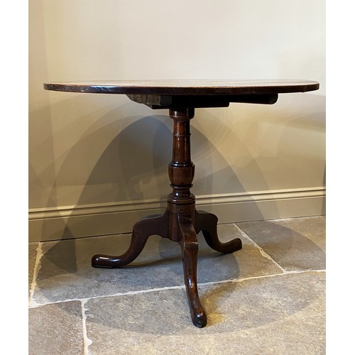 559 - A George III oak tripod table, the circular three plank top on a ring turned baluster column upon th... 