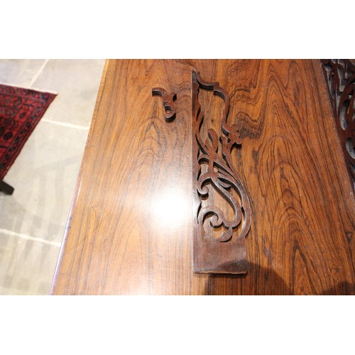 613 - An early Victorian rosewood etagere Canterbury, the four turned finials above a fretwork three quart... 